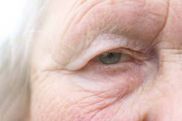 Close-up. Woman aged. Eye in the center of the frame. The pupil has soft focus, the concept of poor...