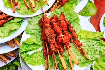 Delicious fried chicken skewers and lettuce on a plate