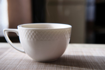 cup of coffee on wooden table steam