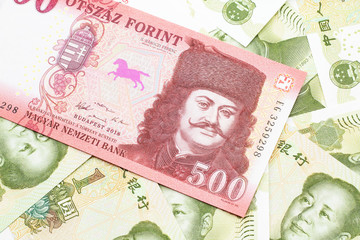 A close up image of a red Hungarian five hundred forint bank note with Chinese one yuan bills in...