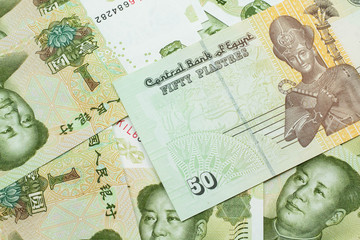 A close up image of an Egyptian fifty pisatres note with Chinese one yuan bills in macro
