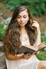 Obraz premium Romantic long haired young beautiful woman reading a book