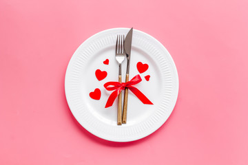 Valentines day table. Plate on pink background top-down copy space