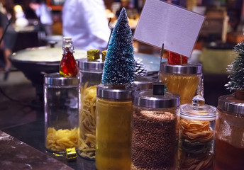 Cooking Chefs keep dry noodle and pasta food ingredients clean in glass jars in kitchen decorated in Christmas Festival theme. Cooking, Recipe, Seasoning, Cuisine, Decoration and Nutrition concept.