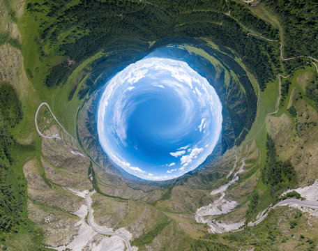 360 Degree Panoramic Image Of An Abstract World Turned Inside Out With Green Meadows Around An Oval Sky With Clouds In Chike-Taman Pass In The Altai Mountains. View From The Earth To The Sky Or Space.