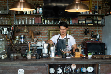 The young man who owns the coffee shop prepares to welcome customers.