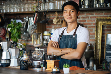 The young man who owns the coffee shop prepares to welcome customers.