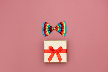Gift box and and LGBT bowtie on pink background