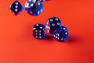 Blue dice on red background close up
