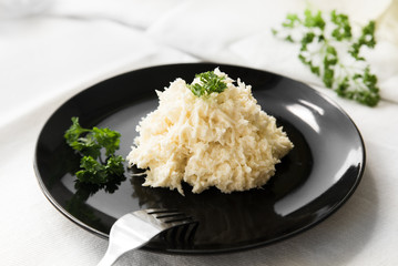Chopped white cabbage salad with mayonnaise on a black plate