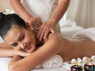 Obraz na płótnie Canvas Beautiful young asian woman lying smile on the bed Getting a Salt Scrub Beauty Treatment in the Health Spa. Body Scrub. Select focus face women