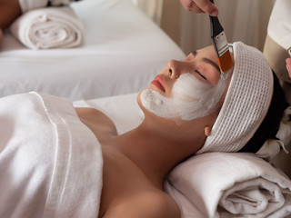 Beautiful young asian woman with facial mask at beauty spa salon. Beauty Treatments