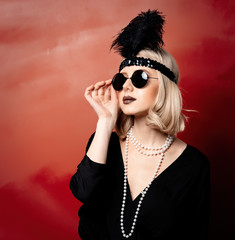 Beautiful blonde woman in twenties years clothes and sunglasses