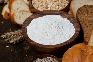 assortment of baked goods and fresh bread on dark background, closeup