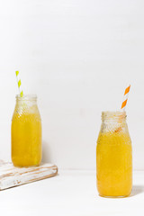 bottles of homemade citrus lemonade on a white background, vertical
