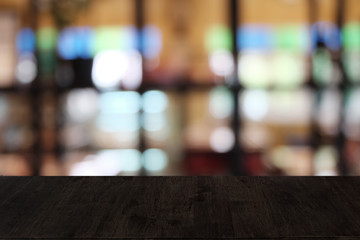 Empty dark wooden table in front of abstract blurred bokeh background of restaurant . can be used for display or montage your products.Mock up for space.