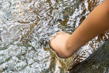 The hand of a child soaking in the clear water