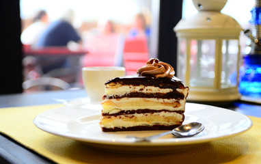 a piece of cake with chocolate and butter cream on a white plate, close-up