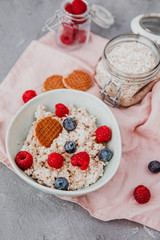 Healthy breakfast porridge oats or oatmeal in bowl with berries. table top view shot. Clean eating concept