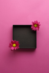 Black empty box. Top view. With purple flowers.