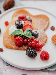 Homemade heart shaped pancakes with berries. Breakfast or brunch for Valentine's Day.