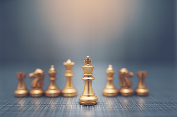 Close up golden chess pieces on dark background