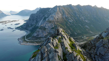 Obraz premium Top view of high stone mountains in Lofoten islands surrounded by the sea