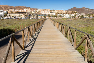 Fototapeta na wymiar wooden bridge running from the beach to Morro Jable - Fuerteventura