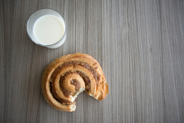 Glass of Milk and Bun on Wood Table.