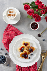 Heart shaped pancakes and a cup of coffee on a gray background. Festive breakfast for Valentine's Day, sweet valentine
