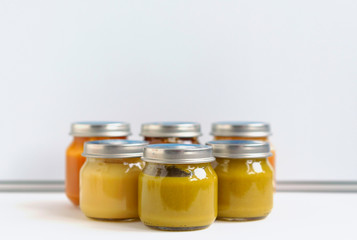 fruit and vegetable baby food in glass jars on a blue background, copy space healthy food for children