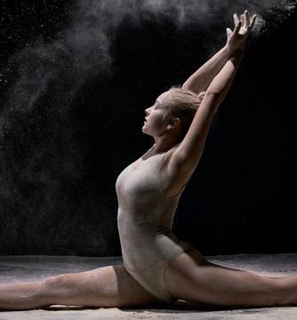 Dancer sitting on stage in cloud of powder