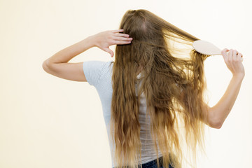 Blonde girl brushing her long hair