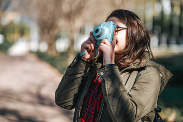 Teenage girl is walking and photographing in her vacation. Tourist, hobby concept.