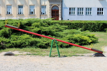 Colorful metal outdoor public playground equipment in shape of seesaw with wooden seats supported...