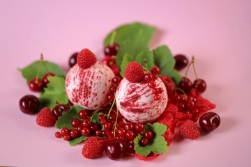 Berry bath bombs set and fresh ripe berries with green leaves on a light pink background.Body...