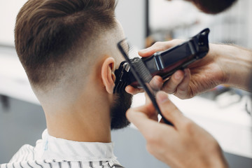 Man with a beard. Hairdresser with a client. Brunette in a barbershop