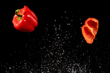 Slices of red peppers falling into the water