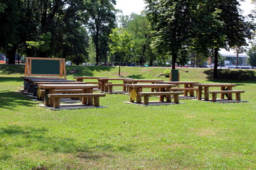 Outdoor classroom with blackboard tables and benches made from strong wooden logs in local public...