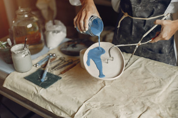 Woman in a pottery. Master make a dishes. Artist works with a clay