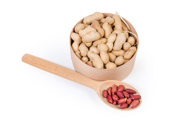 Unshelled peanuts in round box, peeled nuts in wooden spoon