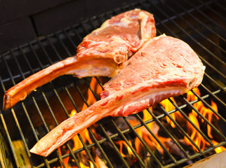 Tomahawk rib beef steak on briks homemade garden hot grill with flames