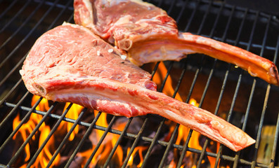 Tomahawk rib beef steak on briks homemade garden hot grill with flames