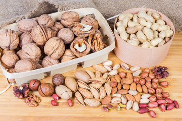 Various shelled and unpeeled nuts on the wooden surface