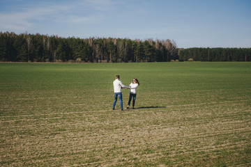 Happy girl and guy running and hugging on the field, love story travel concept, selective focus