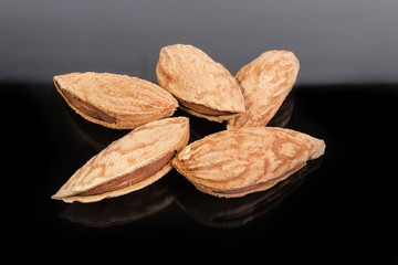 Unshelled almonds close-up on a dark reflective surface