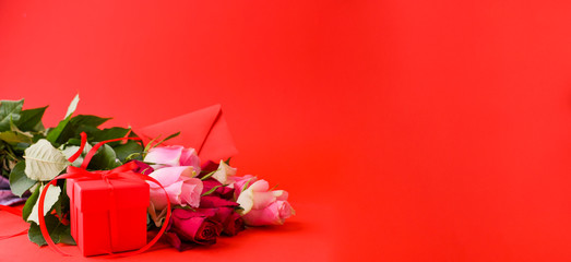 Women's day concept and Valentine's day greeting card. Composition with gift, roses and envelope. Space for text. Banner.