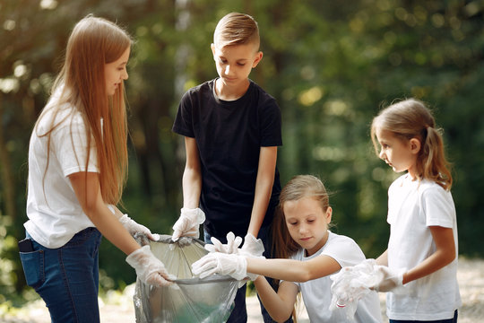 Volunteers Collects Rubbish. Children In A Park. Kids In A White T-shirts