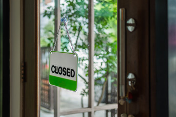 Closed sign hanging on wood door