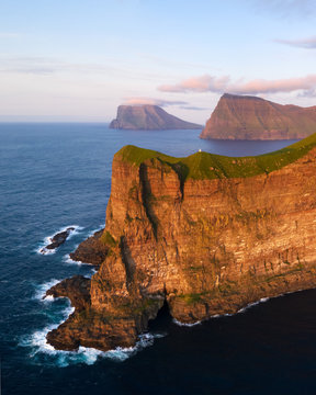 Aerial drone ptoto flying over Kallur lighthouse on green hills of Kalsoy island, Faroe islands, Denmark. Landscape photography